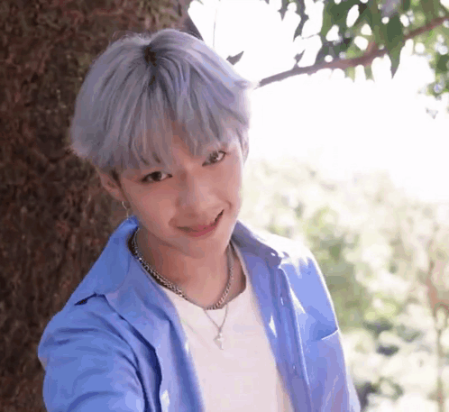 Young Boy With Gray Hair Smiling Next To Tree GIF