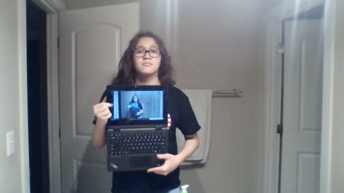 Young Girl Holding Laptop With Woman on Screen