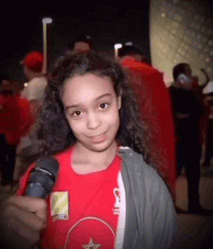 Young Girl in Red Shirt Holding Microphone