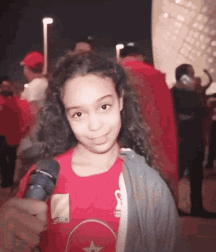 Young Girl in Red Shirt Holding Microphone