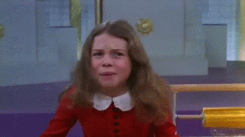 Young Girl in Red Sweater Crying in Front of Yellow Object