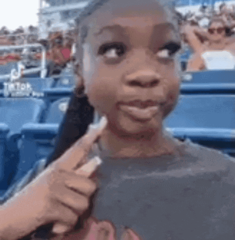 Young Girl in Stadium Pointing Stick at Face