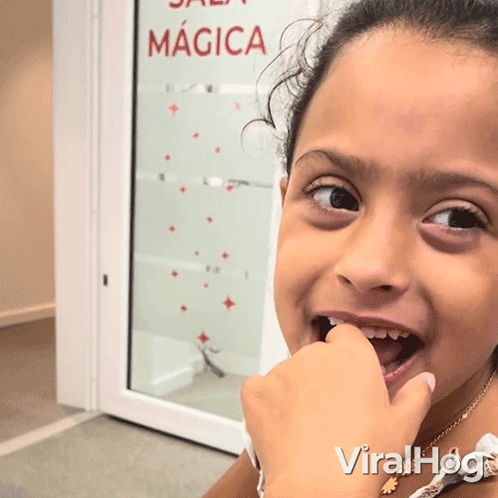 Young Girl Looking at Camera with Sala Magica Sign