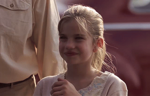 Young Girl Smiling In White Shirt With Blue Embroidery GIF