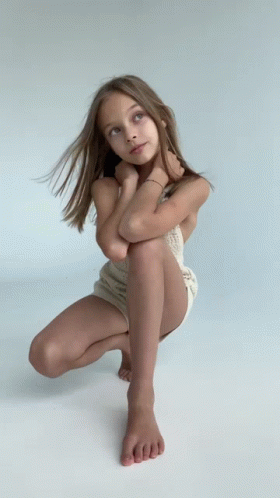 Young Girl Squatting With Legs Crossed Looking Up