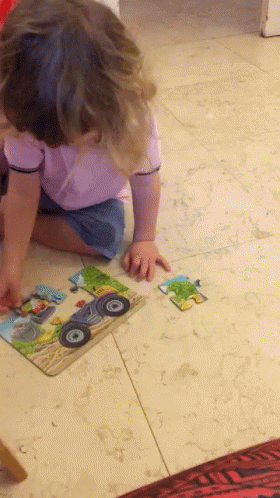 Young Girl Trying To Insert Jigsaw Puzzle Piece GIF