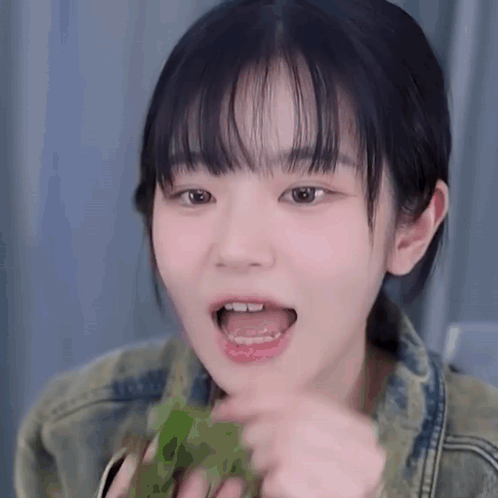 Young Girl With Bangs Eating Green Leaf