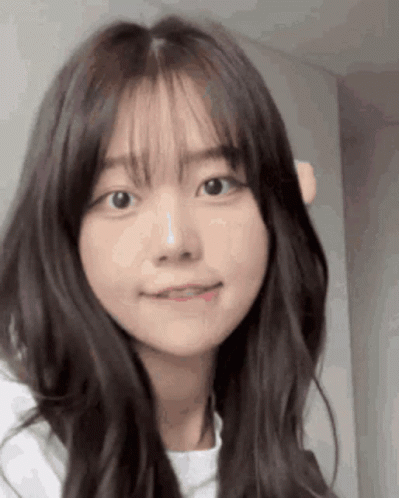 Young Girl With Long Hair and Bangs Looking at Camera