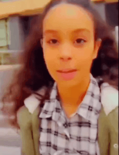 Young Girl With Pigtails in Plaid Shirt and Green Cardigan