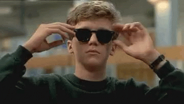 Young Man Adjusting Sunglasses in Library