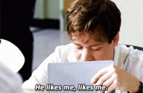 Young Man At Table With Laptop Says He Likes Me GIF