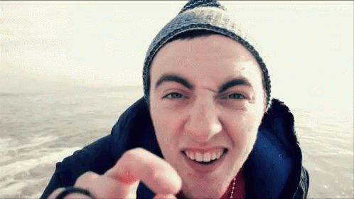 Young Man Beanie Jacket Smiling Pointing at Camera
