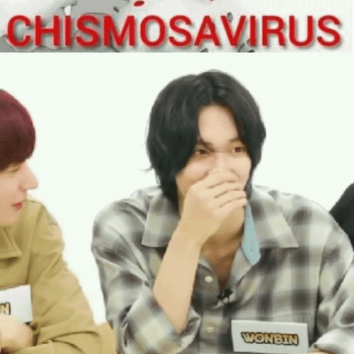 Young Man Covering Mouth Sitting Next to Another Young Man