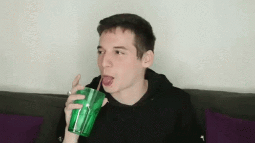 Young Man Drinking Through Straw from Green Cup