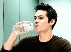 Young Man Drinking Water From Plastic Bottle