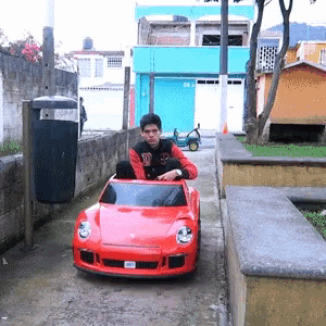 Young Man Driving Red Car With SD License Plate