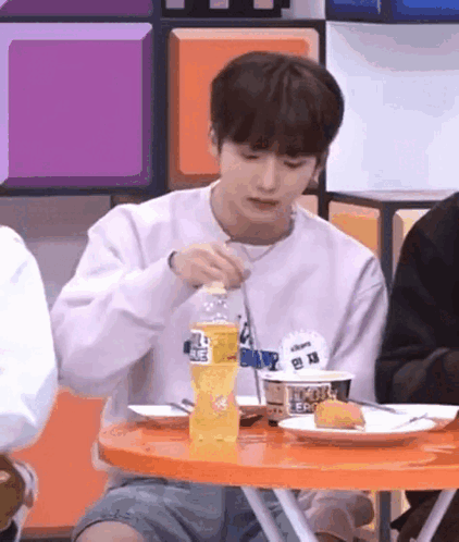 Young Man Eating at Table With Fork and Soda