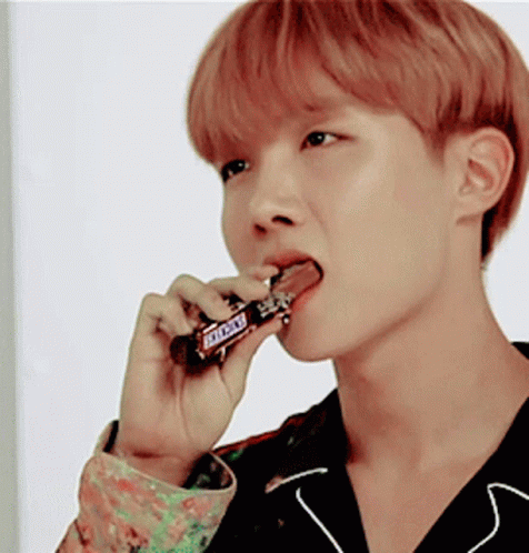 Young Man Eating Snickers Bar With Tongue