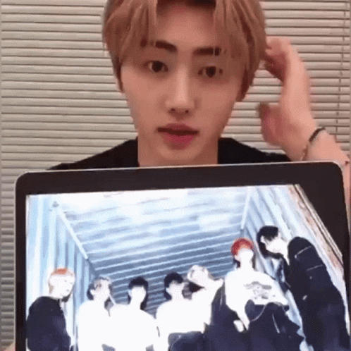 Young Man Holding Laptop With Group Photo on Screen