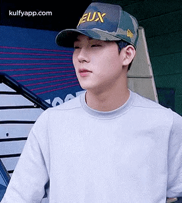 Young Man in Baseball Cap and Gray Sweater