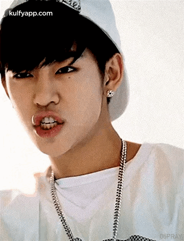 Young Man in Baseball Cap and Necklace Making Face