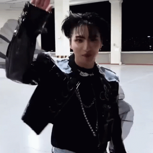 Young Man in Black Jacket and Necklace on Concrete Floor