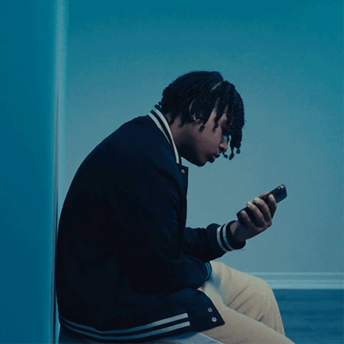 Young Man In Black Jacket Looking At Phone GIF