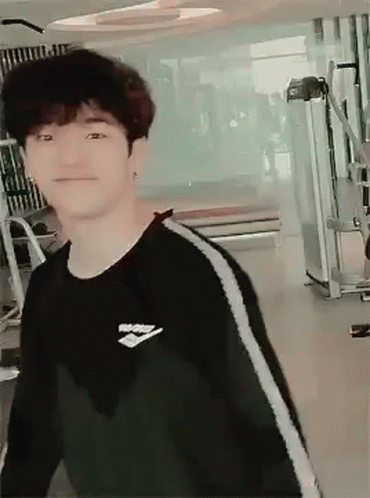 Young Man in Black Sweater Smiling at Gym