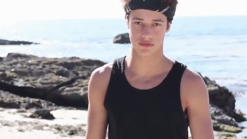 Young Man in Black Tank Top and Headband on Beach