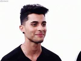 Young Man In Black Turtleneck And Necklace Smiling GIF