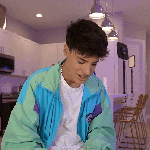 Young Man in Blue and Green Jacket with Letter G