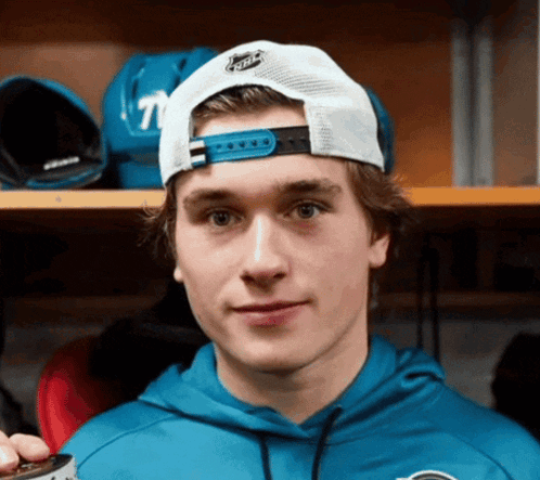 Young Man In Blue Hoodie And White NHL Hat GIF