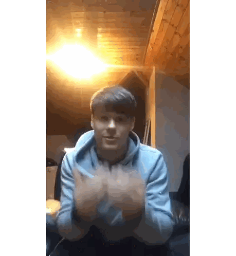 Young Man in Blue Hoodie Clapping