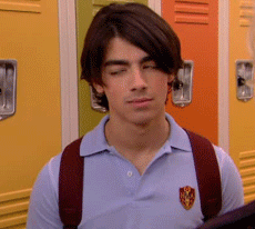 Young Man In Blue Polo And Red Backpack By Lockers GIF