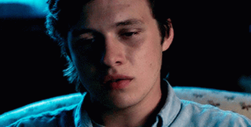 Young Man in Blue Shirt Looking at Camera in Dark