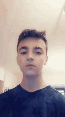 Young Man In Blue Shirt Looking At Camera GIF