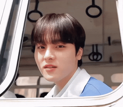 Young Man In Blue Shirt Looking Out Window GIF