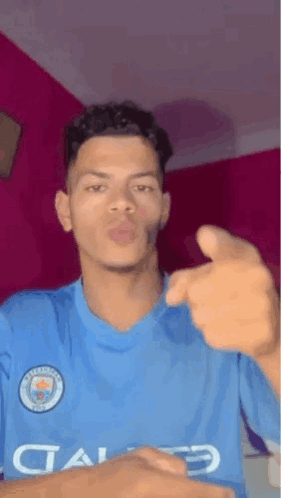 Young Man in Blue Shirt Pointing and Blowing Kiss