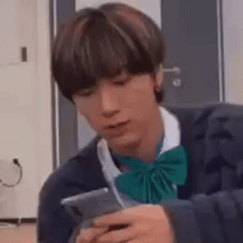 Young Man in Bow Tie Holding Cell Phone