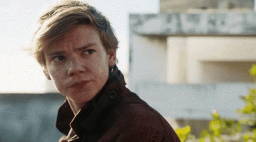 Young Man In Brown Jacket Looking At Camera GIF
