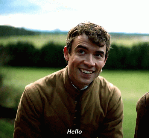 Young Man In Brown Jacket Saying Hello GIF