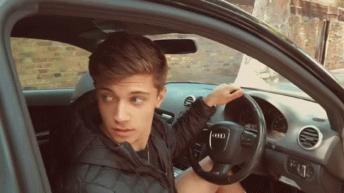Young Man in Car With Audi Logo