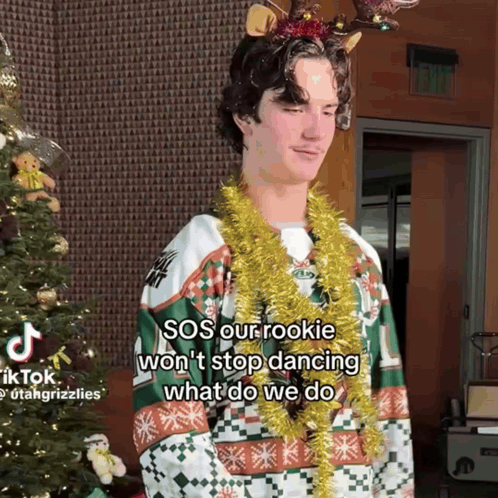 Young Man in Christmas Sweater With Reindeer Antlers