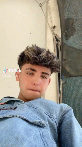 Young Man in Denim Jacket Looking at Camera