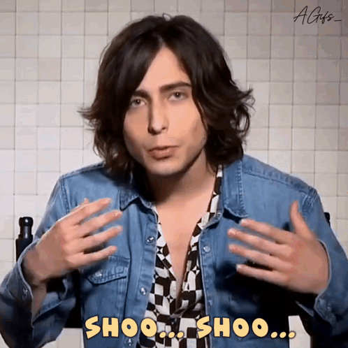 Young Man in Denim Jacket Saying Shoo Shoo