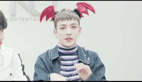Young Man in Devil Wings Headband Making Heart With Hands