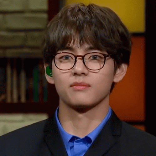 Young Man in Glasses and Blue Shirt Looking at Camera