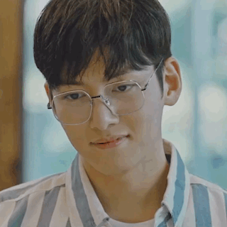 Young Man in Glasses and Striped Shirt Looking at Something