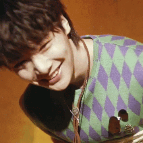 Young Man in Green and Purple Sweater Smiles