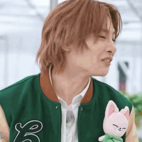 Young Man in Green Jacket Holding Stuffed Animal